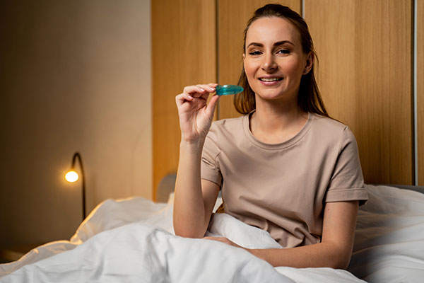 woman holding her oral appliance for sleep apnea before bed